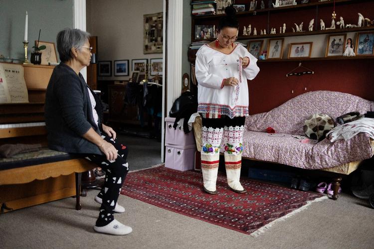 Lisa Bundgaard Jensen dons the East Greenlandic national costume. To the left, her mother Alma Jensen sits and watches. Foto: Thomas Borberg