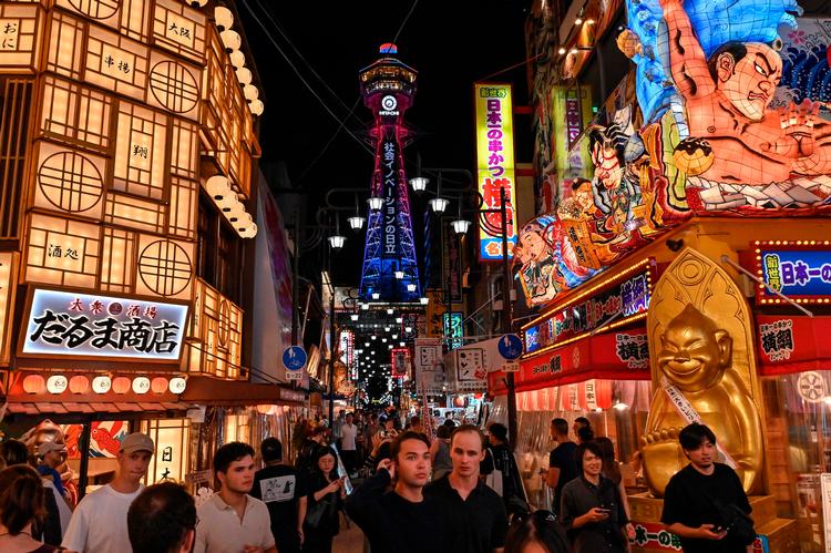 Turister besøger det populære Shinsekai-område i japanske Osaka.  Foto: Richard A. Brooks/Ritzau Scanpix