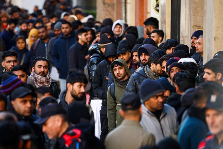 Spanien planlægger at give juridisk status til omkring en halv million papirløse migranter. Forleden stod mange i kø uden for Pakistans konsulat i Barcelona for at søge om en straffeattest, som er et nødvendigt dokument for at få opholds- og arbejdstilladelse. Foto: Albert Gea/Ritzau Scanpix