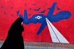 Kan et diplomatisk tiltag fredag forhindre en ny krig mellem Iran og USA? Her går en iransk kvinde forbi et vægmaleri af en amerikansk drone, malet på ydervæggene af den tidligere amerikanske ambassade i Teheran, i daglig tale 'Spionreden'.
 Foto: Atta Kenare/Ritzau Scanpix