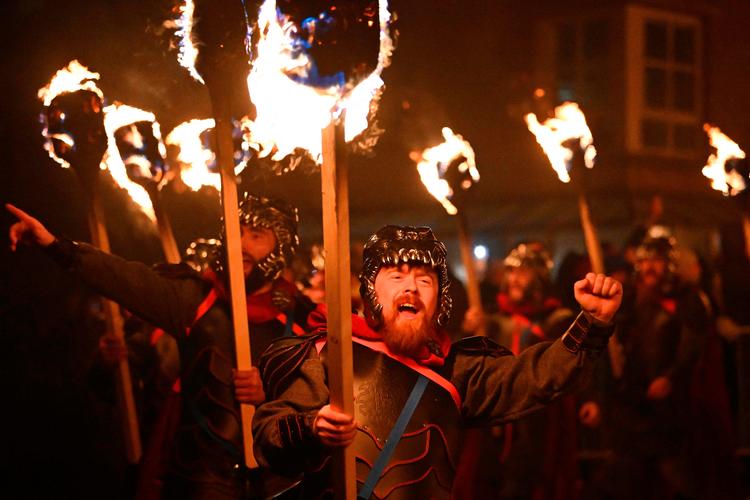 Udklædte deltagere i Up Helly Aa-marchen går med fakler gennem Lerwich og slutter festen med at  sætte ild til en kopi af et vikingeskib. Ildfestivalen på Shetlandsøerne er en hyldest til vikingernes indflydelse på øgruppen.  Foto: Andy Buchanan/Ritzau Scanpix