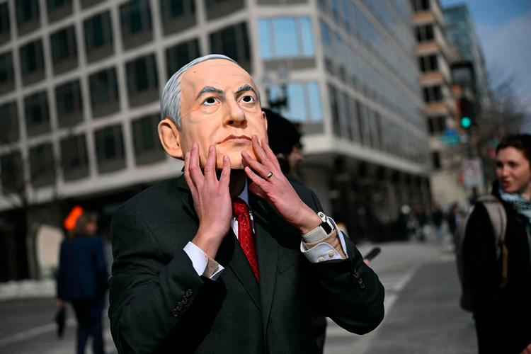En demonstrant iført en maske, der forestiller den israelske premierminister Benjamin Netanyahu, protesterer nær Det Hvide Hus mod Netanyahus besøg i USA. Foto: Brendan Smialowski/Ritzau Scanpix