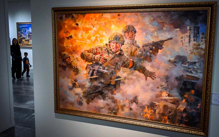 Maleriet forestiller nordkoreanske tropper i kamp. Det indgik som del af udstillingen ’Nordkorea: Et land af storslåede mennesker’ på det Russiske Museum for Dekorativ Kunst i Moskva.  Foto: Alexander Nemenov/Ritzau Scanpix