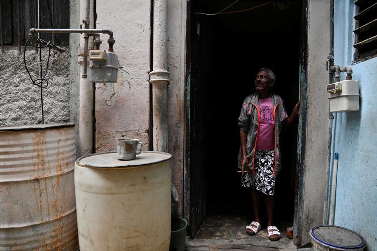 En ældre kvinde ryger en cigar i porten til sit hjem i Havana. USA's pres på Cuba har udløst en massiv økonomisk krise med galopperende priser på mad, brændstof og transport. Foto: Norlys Perez/Ritzau Scanpix