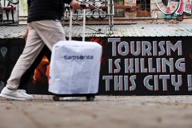 'Turister dræber denne by' står der malet på en mur i den spanske storby Barcelona. Billedet er taget i april 2025. Arkivfoto:  Nacho Doce