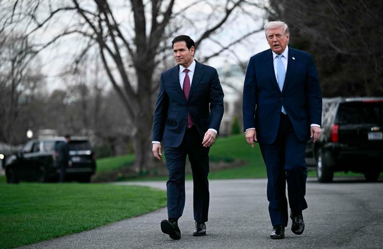 Udenrigsminister og sikkerhedsrådgiver Marco Rubio går - angiveligt i sine for store sko - sammen med Trump ved Det Hvide Hus en fredag i marts, hvor Trump forlader Washington for at tage til Mar-a-Lago. Foto: Brendan Smialowski/Ritzau Scanpix