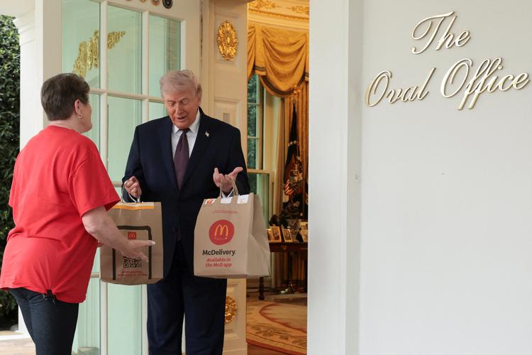 Den amerikanske præsident Donald Trump modtager en McDonald's-levering via DoorDash fra Sharon Simmons uden for Det Ovale Værelse i Det Hvide Hus i Washington, D.C., USA, 13. april 2026. Foto: Jonathan Ernst/Ritzau Scanpix