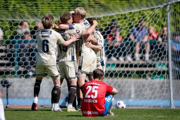 Lyngbys William Steindorsson har scoret til 0-2, og der jubles. Hvidovres Malthe Killerich sidder på græsset. Foto: Jens Dresling