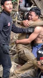 En af de personer, der blev reddet ud af en oversvømmet hule i Laos, omfavner redningsfolkene. Foto: Chakkrit Taengtang/Ritzau Scanpix