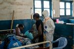 Christiane Bahati er indlagt på Mongbwalus eneste hospital med ebola og får hjælp af en slægtning og en sundhedsarbejder. Der er lang fra beskyttelsesudstyr til alle. Få timer senere døde den 21-årige mor til to..  Foto: Arlette Bashizi/Ritzau Scanpix