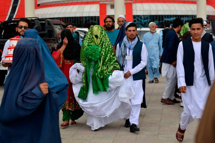 Et nygift afghansk par forlader bryllupsstedet i Kabul. Ny lov om ægteskab i Afghanistan får hård kritik for overtrædelse af kvinders rettigheder.   Foto: Sahel Arman/Ritzau Scanpix