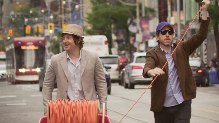 Matt Johnson og Jay McCarrol i færd med at rulle et kabel ud i Torontos gader. Det involverer en tidsmaskine, et 365 meter højt tårn og en hulens masse Frankenstein-elektricitet. Mere skal ikke røbes. Still fra filmen Foto: /Rio