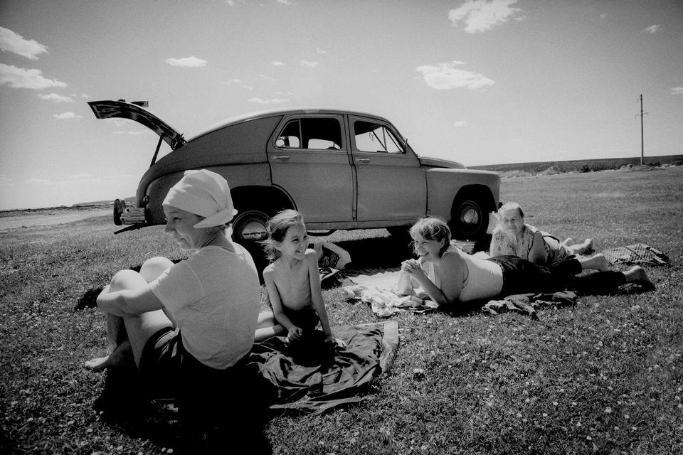 (Rusland ved Ulan-Ude, tæt ved Mongoliet, 1994).  »Vi kørte gennem et åbent og slidt landskab, hvor vi pludselig passerede en familie på søndagsudflugt i solen. Bedstefar Lubimov tog sig en lur i den gamle Volga fra 1947, mens Olga, Irina og barnebarnet Anastasia sad i lyset. Et stille øjeblik i et område, hvor fred og konflikt hele tiden skiftede plads«.  Foto: Carsten Ingemann/INGEMANN PHOTOGRAPHY