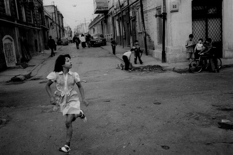 (Baku, Aserbajdsjan, 1994).  »Taget under en rejse gennem Kaukasus sammen med Thomas Heine. En pige løb over en gade, og motivet opstod pludseligt – ud af det blå. Efter Sovjetunionens opløsning var regionen i forandring, hvor gamle religiøse og kulturelle linjer igen trådte frem. Baku var både en olieby og en karavaneby, hvor det nye og det gamle stod side om side i samme øjeblik«.  Foto: Carsten Ingemann/INGEMANN PHOTOGRAPHY