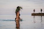 En kvinde med blomsterkrans på hovedet er gået ud i vandet ved sortehavsbyen Odesa under midsommernatten Ivan Kupala.  Foto: Oleksandr Gimanov/Ritzau Scanpix