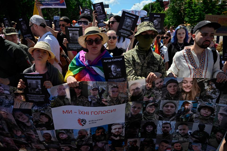 LGBTQ+-parade 21. juni i Kyiv, hvor deltagerne viste billeder af soldater fra deres inderkreds. Under den mere end fire år lange krig er både synet på minoriteter og traditionelle kønsroller i markant bevægelse i Ukraine.  Foto: Genya Savilov/Ritzau Scanpix