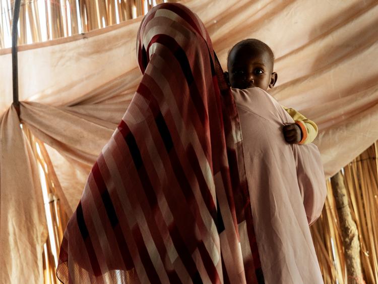 Daralnaeem holder sin søn Muhammad i flygtningelejren Goz Salaam nær Kosti i Sudan. »Jeg elsker ham«, siger hun om Muhammad, på trods af de smertefulde minder hans fødsel vækker. Foto: Mads Nissen