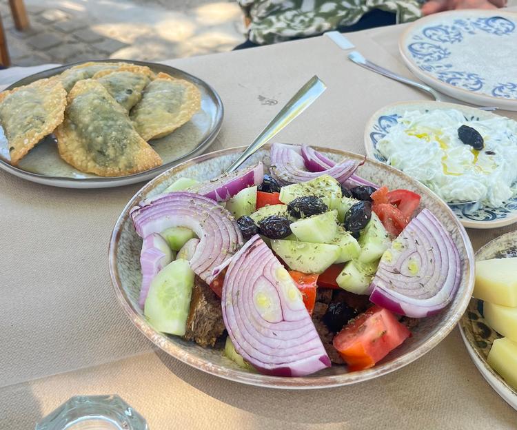 Til et helt traditionelt måltid hører græsk salat, kalitsounia og tzatziki med en oliven på toppen. Foto: Torben Kitaj