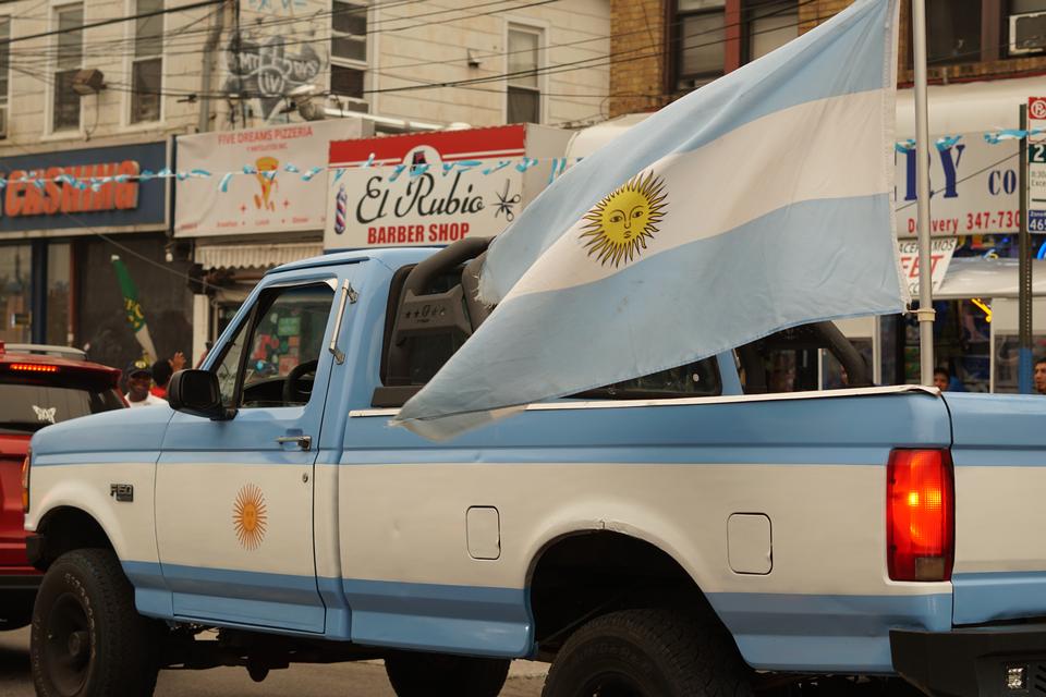 En pickup malet i Argentinas blå-hvide farver kører gennem Queens med et kæmpe argentinsk flag bølgende fra ladet efter sejren over England. Foto: Anders Tornsø Jørgensen