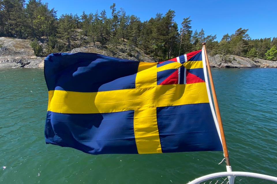 Selvom skærgården nogle steder sender tanker mod Middelhavet, er man med de blå og gule farver sjældent i tvivl om, at vi er er i broderlandet hinsidans.  Foto: Kristoffer Flakstad