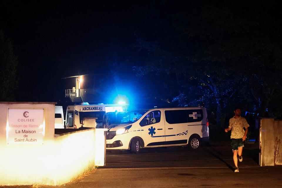 En ambulance forlader et plejehjem i Saint-Aubin-de-Médoc, mens en skovbrand raser i nærheden. Branden udvikler sig på baggrund af forværrede tørkeforhold efter en hedebølge og udbredt vandmangel i store dele af Frankrig. Billedet er taget den 25. juli 2026. Foto: Manon Cruz/Ritzau Scanpix