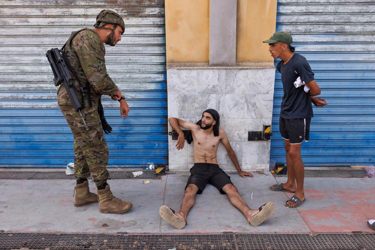  En mand kommer humpende med en fod, der muligvis er brækket. Soldaterne tilkalder en militærambulance. Han får bundet foden ind, så han kan humpe videre mod grænsen. Foto: Jacob Ehrbahn