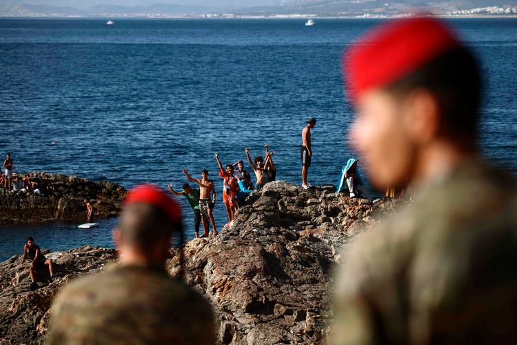 Spanske soldater i Ceuta overvåger migranter ved grænsen til Marokko. Foto: Henry Nicholls/Ritzau Scanpix