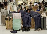 Folk lagde sig til at sove i Narita-lufthavnen i Tokyo efter at være strandet i tusindvis på grund af rekordstor mængde regn. Foto: Tom Bateman/Ritzau Scanpix