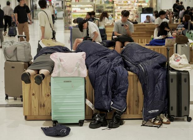 Folk lagde sig til at sove i Narita-lufthavnen i Tokyo efter at være strandet i tusindvis på grund af rekordstor mængde regn. Foto: Tom Bateman/Ritzau Scanpix