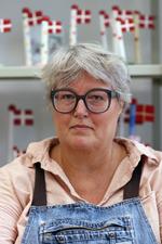 Annemette Klit-Nygaard har designet og laver keramikflag til festlige lejligheder. Det gav hende en blomstrende gesjæft med mange ansatte, men i dag er det kun hende. For da der begyndte at komme andre flag på markedet, som lignede hendes til forveksling, ændrede alt sig.   Foto: Anne Rumland Østbygaard