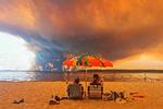 Fra stranden Moutchic i det sydvestlige Frankrig kan solbadende turister se over på røgskyerne fra naturbrande  24. juli. Rekordstore områder er brændt af i Frankrig denne sommer. Foto: Maximilien Lamy/Ritzau Scanpix