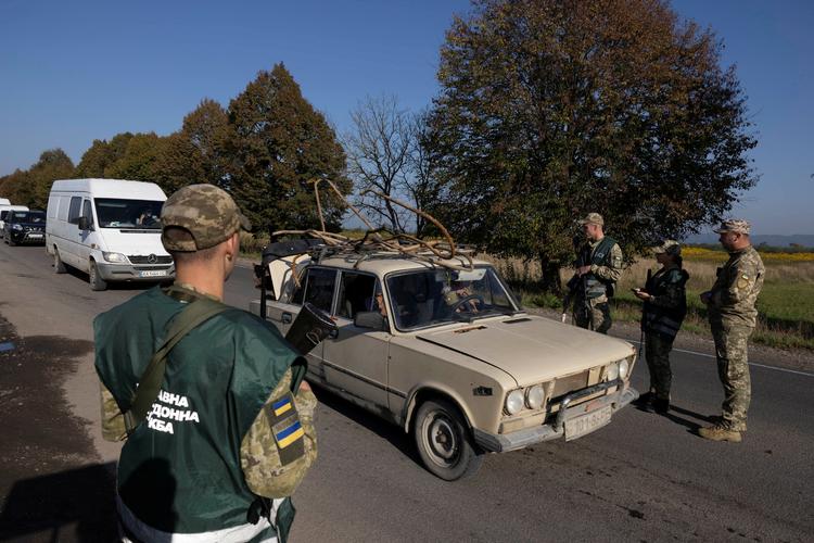 Ukrainske grænsevagter og militære rekrutteringsofficerer tjekker folks papirer ved et kontrolsted tæt ved grænsen til Rumænien. Ukrainske mænd mellem 23 og 60 år, som kan mobiliseres, må ikke krydse grænsen uden særlig tilladelse. Foto: Thomas Peter/Ritzau Scanpix