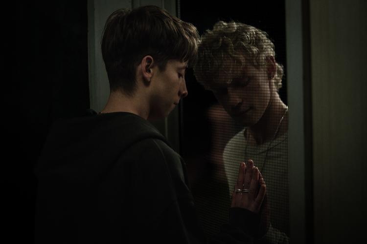 Naim og Ryan ved begge, at den anden kan være dæmonen i forklædning. Så køkkendørens fluenet er en både dejlig tynd og farligt skrøbelig beskyttelse mellem dem.  Foto: Neon