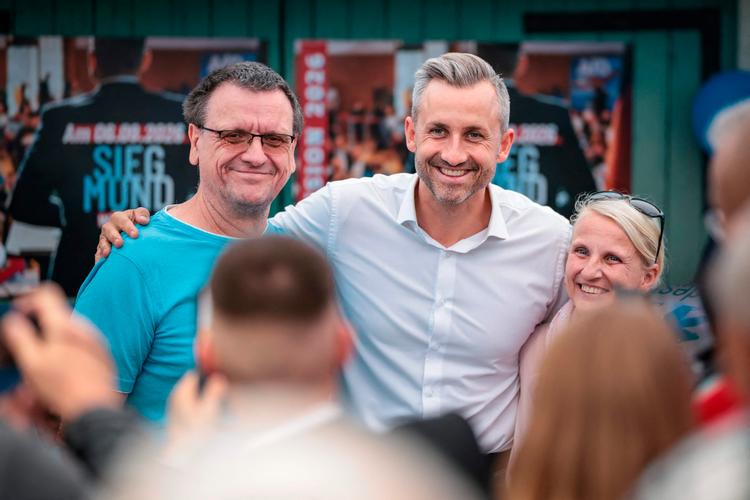 Ulrich Siegmund, spidskandidaten fra Alternative für Deutschland i Sachsen-Anhalt krammer og poserer til højre og venstre ved partiets demokratifest i den lille østtyske by Haldensleben.   Foto: Ronny Hartmann/Ritzau Scanpix