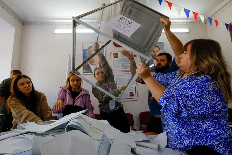  Members of a local electoral commission empty a ballot box before counting votes as they stand near portraits of Russian President Vladimir Putin and Denis Pushilin, Moscow-installed leader of the Russian-controlled parts of the Donetsk region, on the final day of Russia's three-day parliamentary election, amid the Russia-Ukraine conflict in Donetsk, a Russian-controlled city of Ukraine, September 20, 2026. REUTERS/Alexander Ermochenko TPX IMAGES OF THE DAY   Foto: Alexander Ermochenko/Ritzau Scanpix