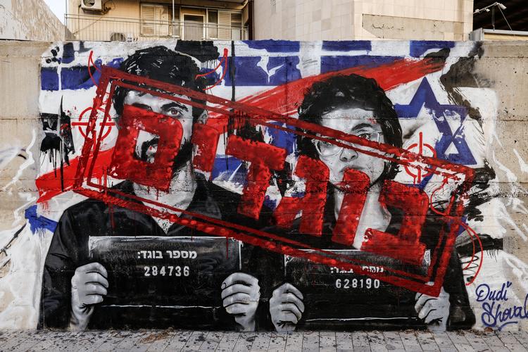 'Forrædere' står der hen over et billede af de to instruktører bag filmen 'Nasa', Yuval Abraham og Rachel Szor, på en mur i den israelske by Hebron. Foto: Amir Cohen/Ritzau Scanpix