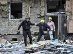 En beboer hjælpes ud af sit beskadigede hjem efter et nyt russisk angreb i Ukraine. Foto: Stringer/Ritzau Scanpix