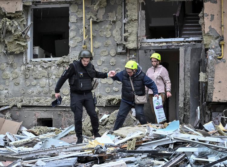 En beboer hjælpes ud af sit beskadigede hjem efter et nyt russisk angreb i Ukraine. Foto: Stringer/Ritzau Scanpix