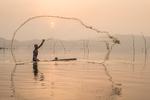 En enlig fisker kaster sit net ud i  Bosumtwi-søen i det centrale Ghana ikke langt fra byen Kumasi.  