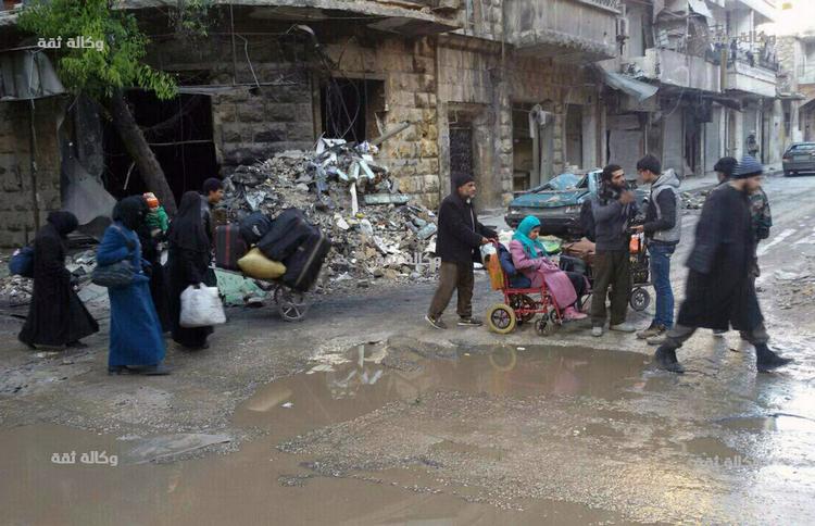 Civile samler sig i Østaleppo for at blive evakueret ud af byen. (Thiqa News via AP) 
