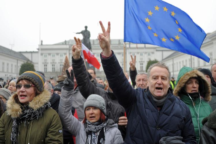 Demonstranter synger Polens nationalsang i Warszawa.  