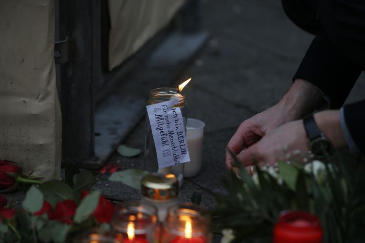 En person ved lys og blomster, tirsdag formiddag på Markedet på Breitscheidplatz foran Gedächtniskirke i det centrale Berlin.  