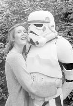 Carrie Fisher giver en krammer til en uidenticeret person, klædt ud som Storm Trooper, i 1980.  