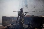 Somalias hovedstad,  Mogadishu, er stadig præget af terrorangreb. Bag soldaten ses resterne af en bil, som blev brugt ved et selvmordsangreb 31. juli.  Ni mennesker mistede livet. 