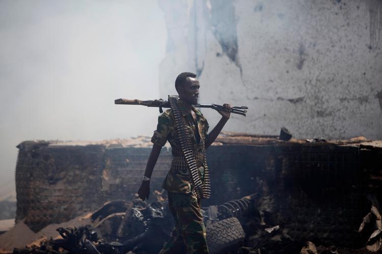 Somalias hovedstad,  Mogadishu, er stadig præget af terrorangreb. Bag soldaten ses resterne af en bil, som blev brugt ved et selvmordsangreb 31. juli.  Ni mennesker mistede livet. 