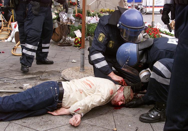 Betjente hjælper voldsoffer under sammenstød mellem fodboldfans i København. Arkivfoto. 