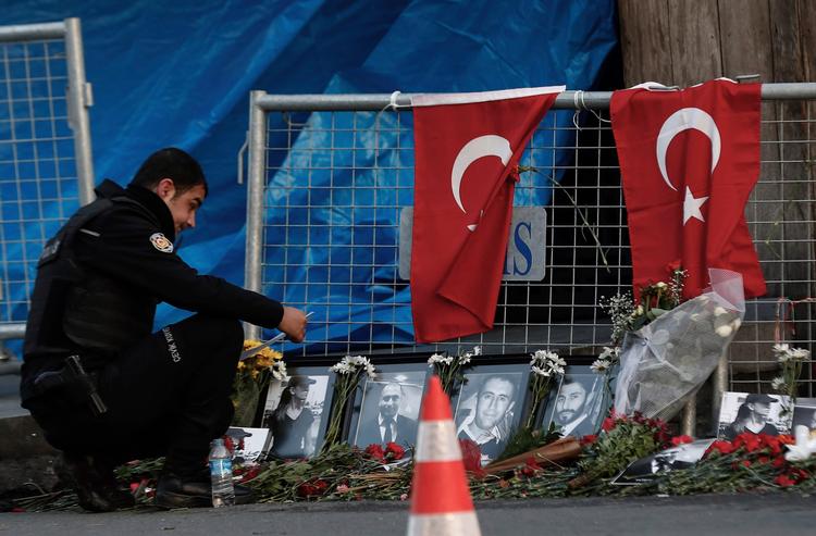 En politimand kigger på fotografier af ofrene efter et terrorangreb på en natklub i Istanbul to dage tidligere. Gerningsmanden er ikke fanget. 
