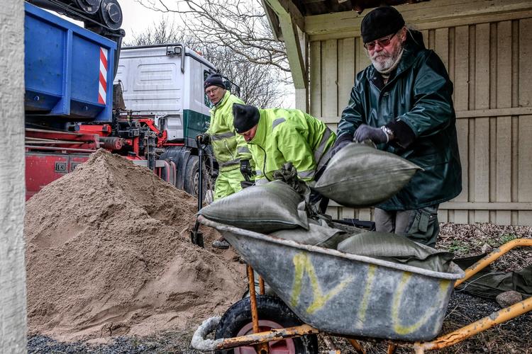 Mange sommerhusejere har hele daget forsøgt at skærme deres huse med sandsække. Her ses nogle af dem ved Korsør i gang med at lave sandsække. 