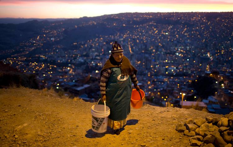 En kvinde bærer to spande med vand i La Paz i Bolivia. Landets præsident, Evo Morales, bad i november om tilgivelse for, at byens indbyggere havde begrænset vandforsyning som følge af den værste tørke i 25 år.  