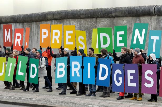 Protesterne holder sig dog ikke kun indenfor USA's grænser. Her kommer protesterne fra miljøorganisationen Greenpeace ved mindesmærket for Berlinmuren i Berlin.
  